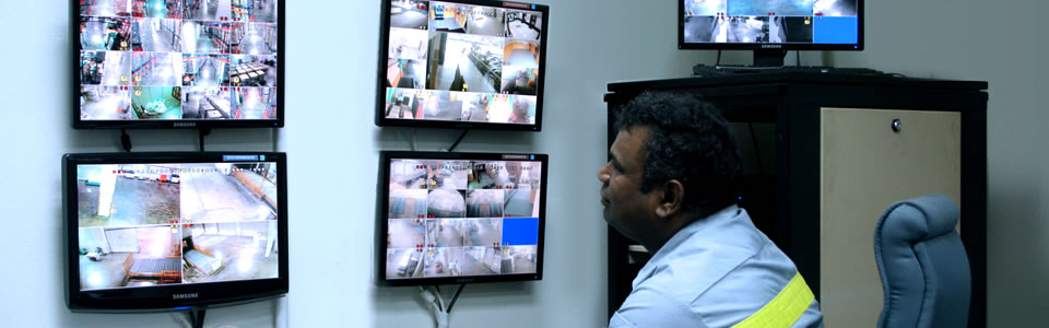 An ILS security officer monitoring a wall of CCTV screens
