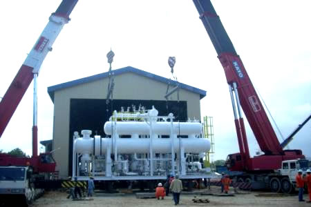 Two mobile cranes tandem-lifting a skid-mounted process module into position