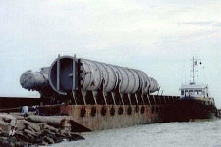 A large process vessel secured on a barge at sea